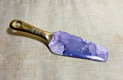 Contemporary cake server with purple marble blade and gold handle