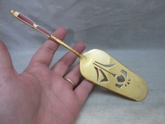 Gold plated cake server with red enamel handle