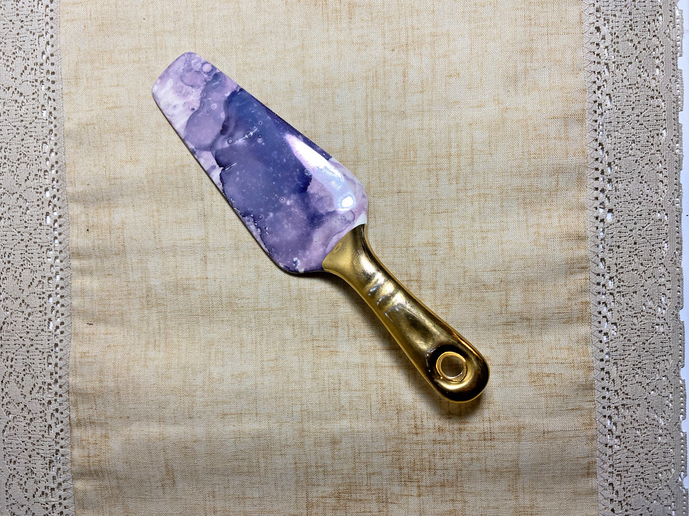 Contemporary cake server with purple marble blade and gold handle